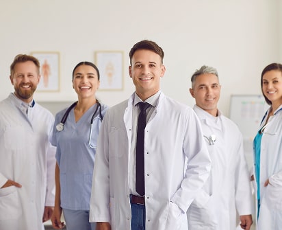 Group of physicians in lab coats and scrubs, illustrating Polymath Investments’ specialized financial services for doctors and healthcare professionals.